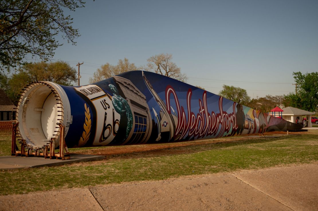 A turbine blade lies outside the Weatherford city hall. A local artist is in the process of painting a mural on it.