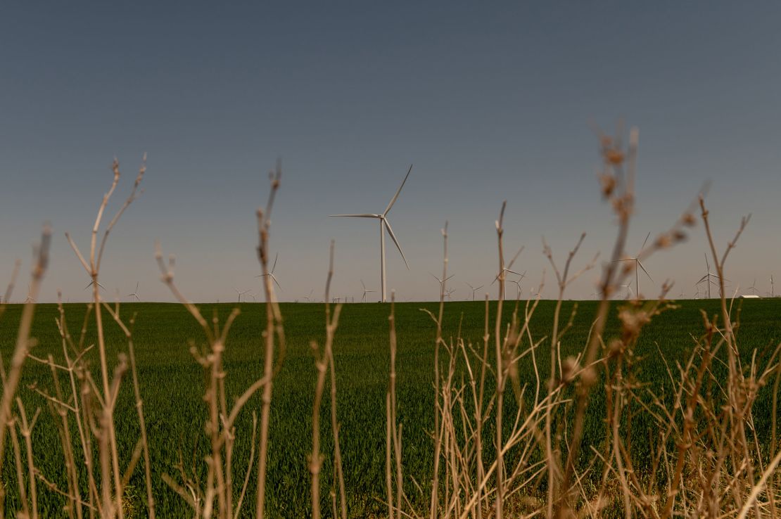 A wind turbine spins over a wheat field in Weatherford.