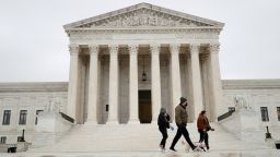 Visitors walk across the Supreme Court Plaza during a storm on Capitol Hill in Washington, DC, on February 22, 2022.