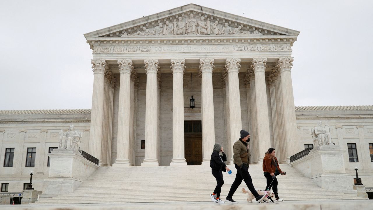 Visitors walk across the Supreme Court Plaza during a storm in February 2022.
