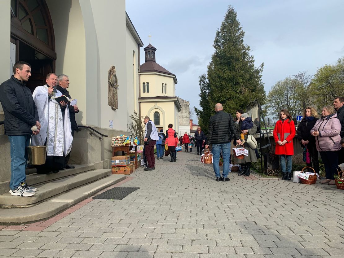 A priest reminds parishioners of Jesus' sacrifice from the steps of the Church of the Intercession of the Blessed Virgin in Lviv, Ukraine on April 23, 2022. 