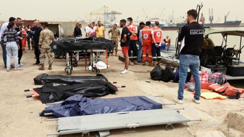 Emergency services workers and stretchers stand ready on April 24, 2022, after a boat capsized off the coast of Tripoli, Lebanon, overnight.