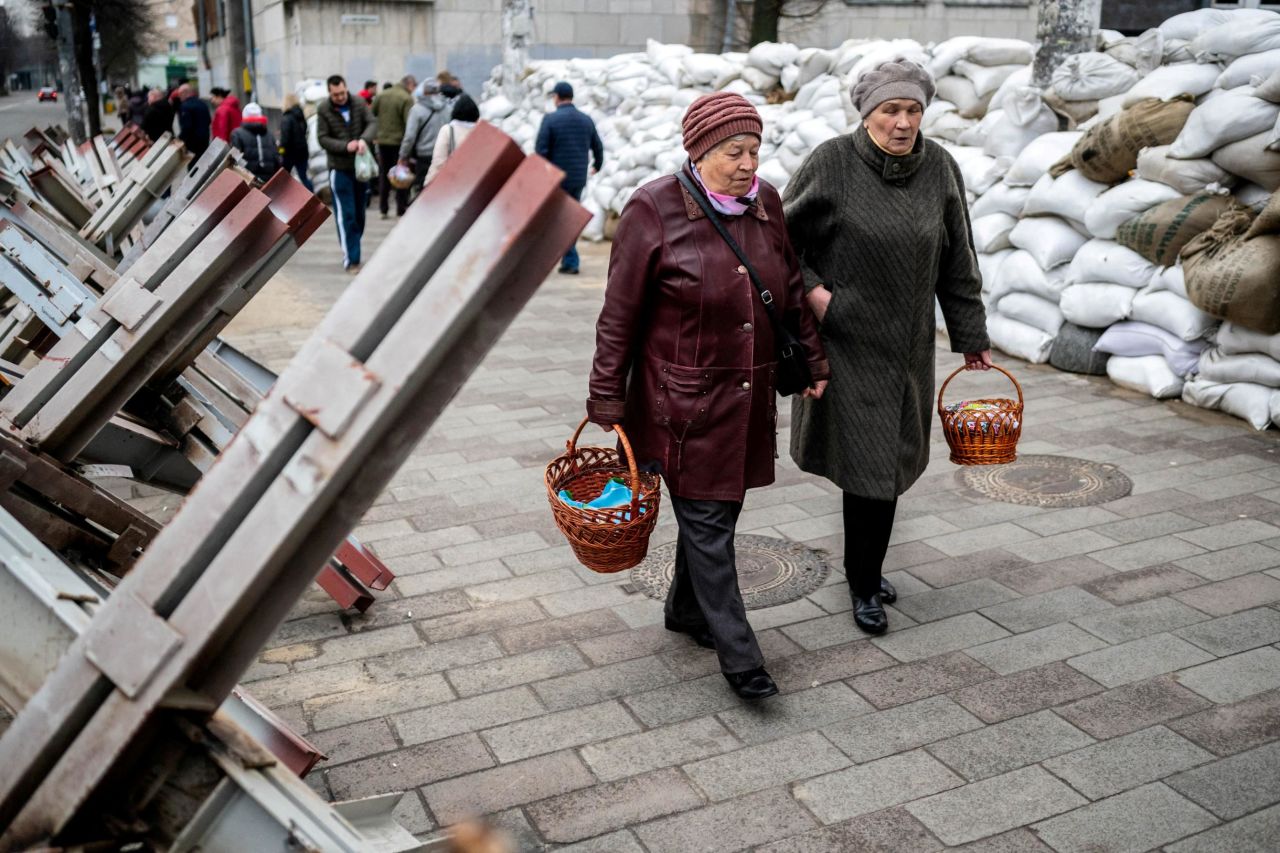 Women walk between sandbags and anti-tank barricades in Zhytomyr, Ukraine, to attend a blessing of traditional Easter food baskets on April 23.  Zelensky says Russia waging war so Putin can stay in power &#8216;until the end of his life&#8217; 220425090155 01 ukraine gallery update 042522