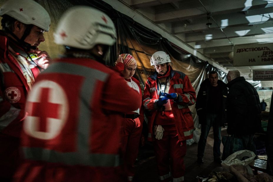 Members of the Ukrainian Red Cross talk before moving an elderly woman to an ambulance in a bunker under a factory in Severodonetsk, Ukraine, on April 22.