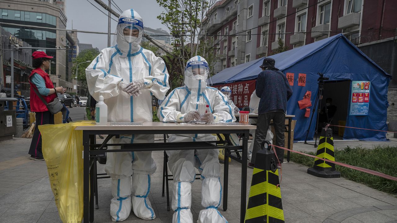 Health workers wait to tests residents in the Chaoyang District on April 25, 2022 in Beijing, China.