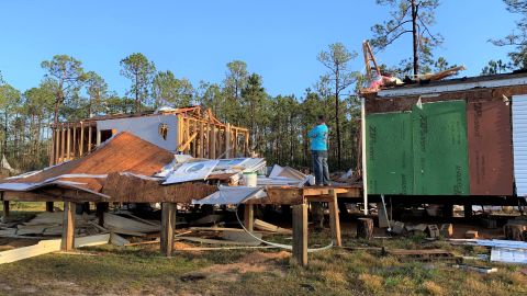 A homeowner stands in the middle of his trailer home cut in half by a tornado which touched down in Vancleave, Mississippi, on March 31, 2022.