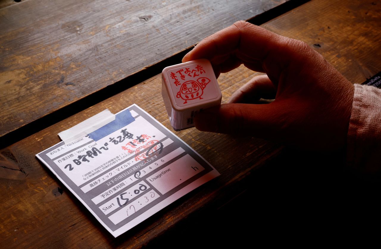 Takuya Kawai, owner of the Manuscript Writing Cafe, shows a slip of paper on which customers write down their goals.