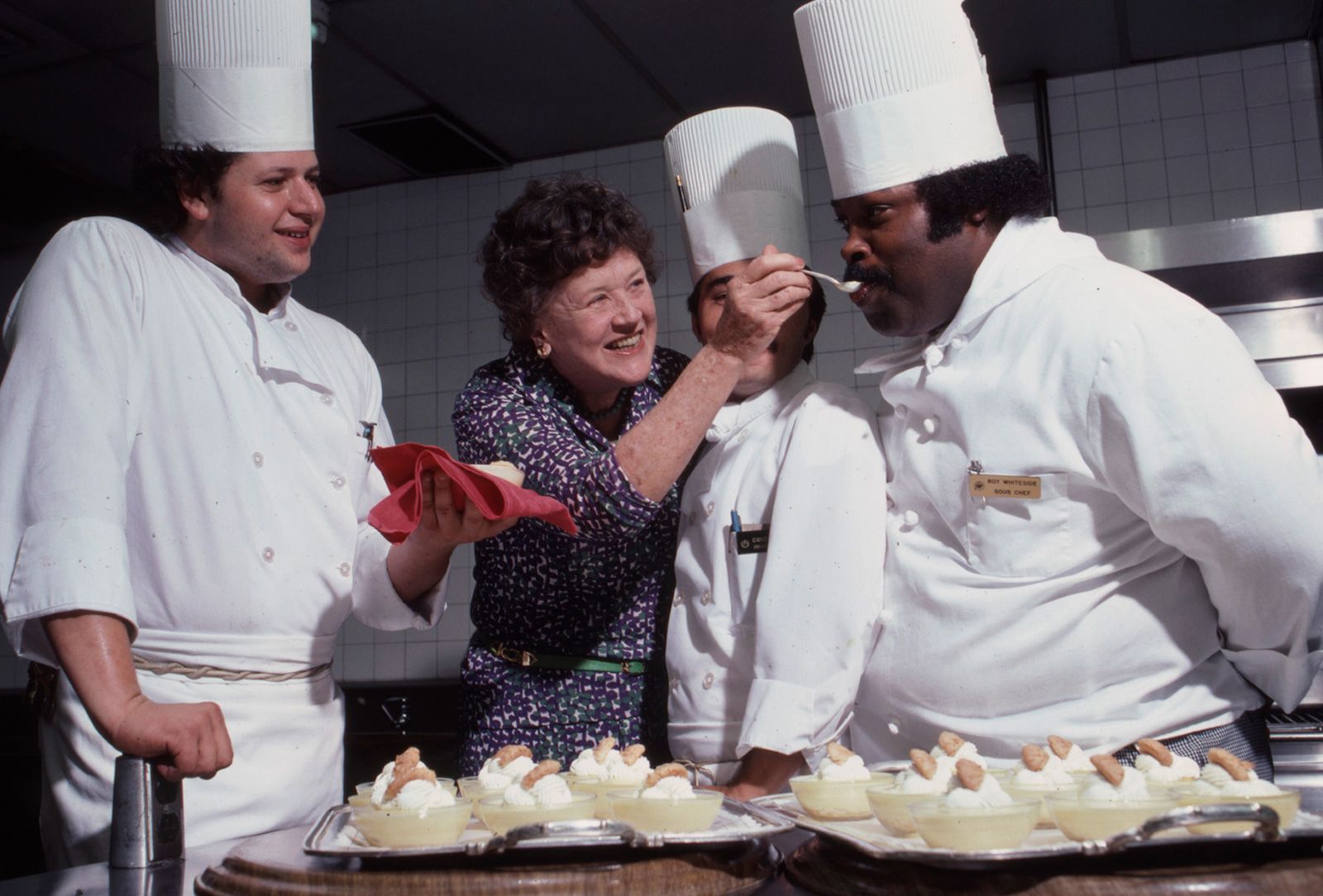 Child feeds a fellow chef in 1979.