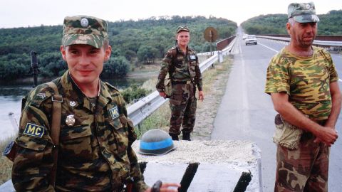 A Russian officer (left), a Moldavian soldier (center) and a Transnistrian solder (right) stand on guard in the security zone, separating Moldova and Transnistria along the Dniester River, in 2002.