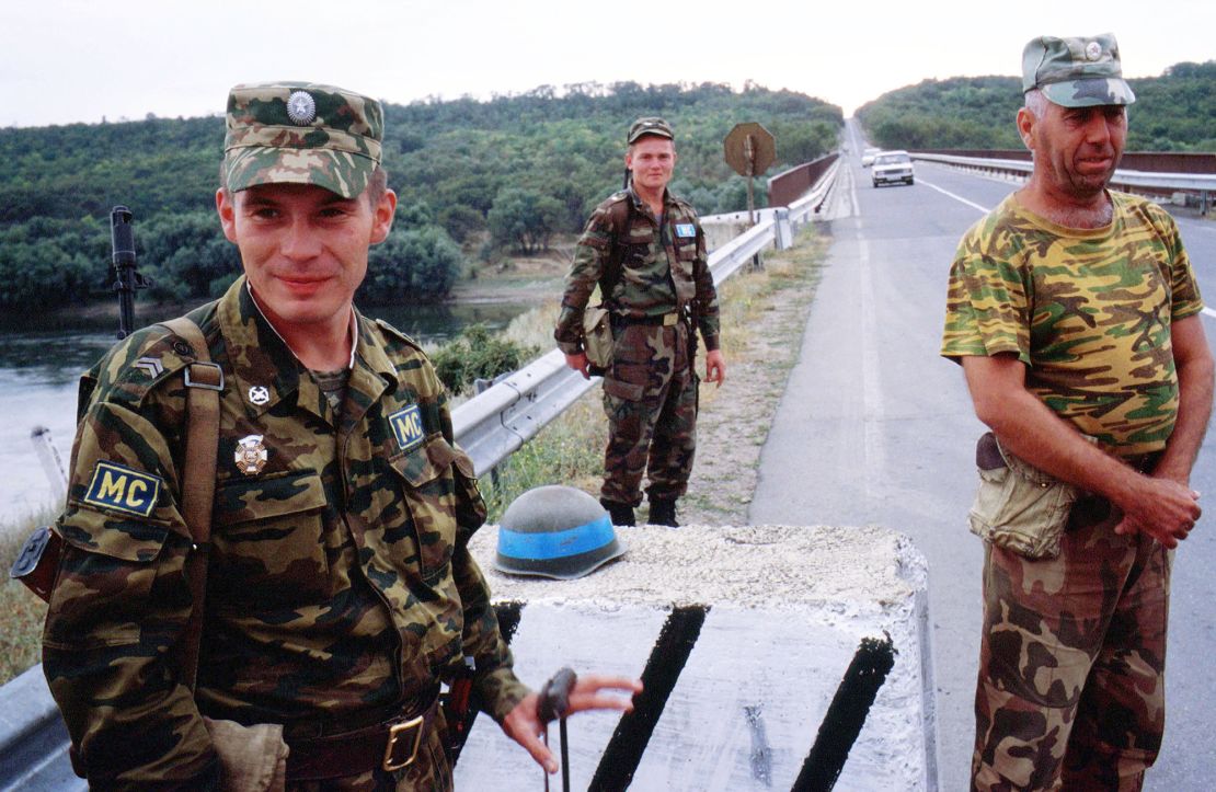 A Russian officer (left), a Moldavian soldier (center) and a Transnistrian solder (right) stand on guard in the security zone, separating Moldova and Transnistria along the Dniester River, in 2002.