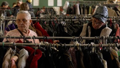 Evacuees look through racks of donated clothing at the Kryvyi Rih hall.