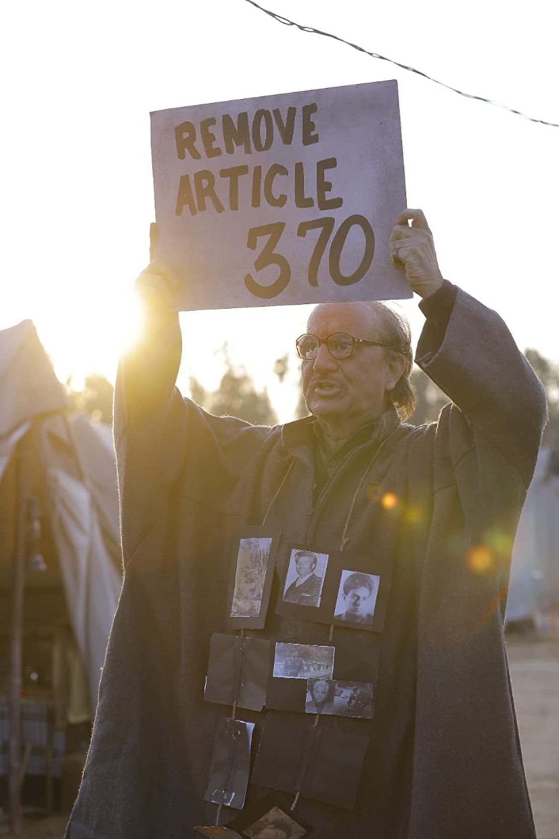 Indian actor Anupam Kher holds a "Remove Article 370" sign in "The Kashmir Files."