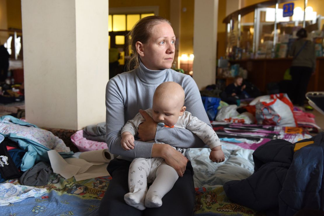 Ksenia, a 32-year-old from Kyiv, cradles her 6-month-old son Oleksandr. "The children were waking up at night because of explosions, they were scared," she said, describing the days before they fled.