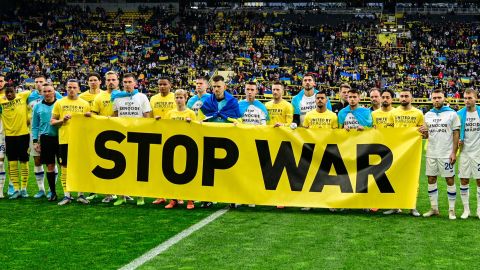 Players of both teams stand behind an anti war banner prior to the friendly fund-raising football match BVB Borussia Dortmund v Dynamo Kyiv in Dortmund, western Germany, on April 26, 2022. - DFL REGULATIONS PROHIBIT ANY USE OF PHOTOGRAPHS AS IMAGE SEQUENCES AND/OR QUASI-VIDEO (Photo by Sascha Schuermann / AFP) / DFL REGULATIONS PROHIBIT ANY USE OF PHOTOGRAPHS AS IMAGE SEQUENCES AND/OR QUASI-VIDEO (Photo by SASCHA SCHUERMANN/AFP via Getty Images)
