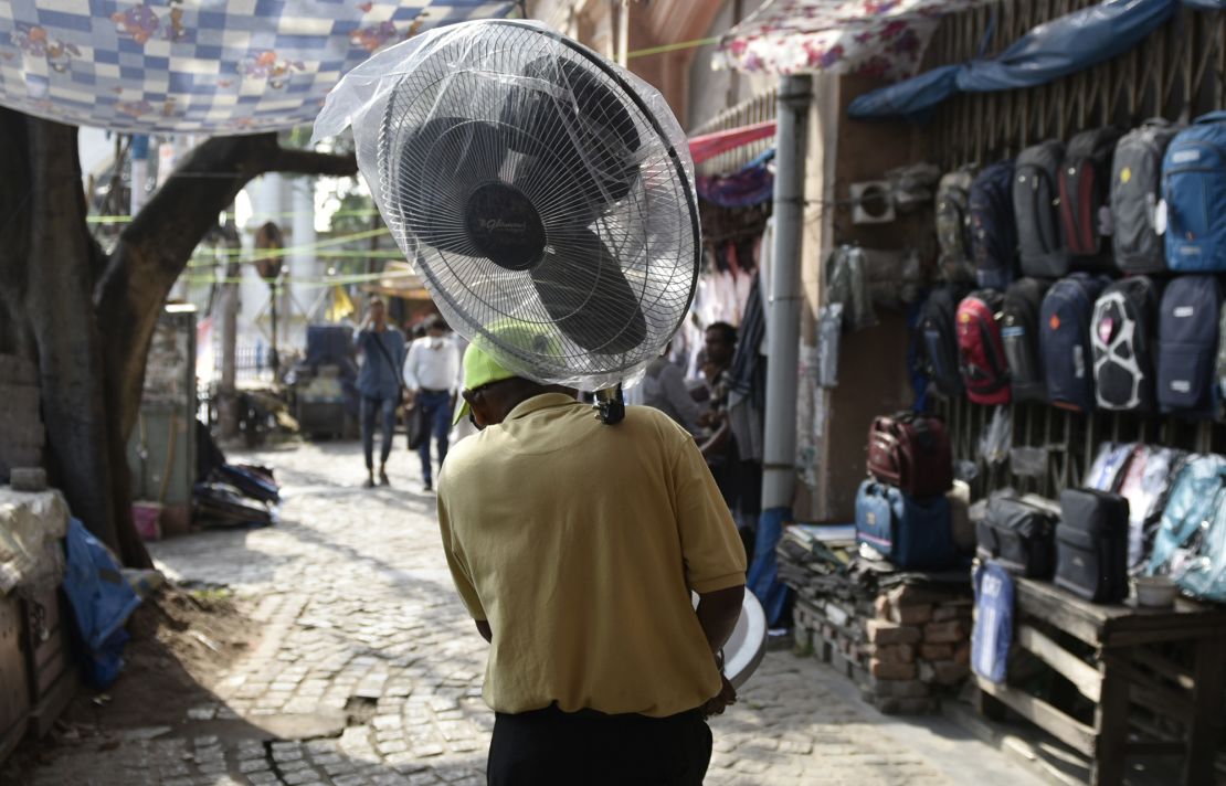 A man carries a pedestrial fan amid a heat wave in Kolkata, India.