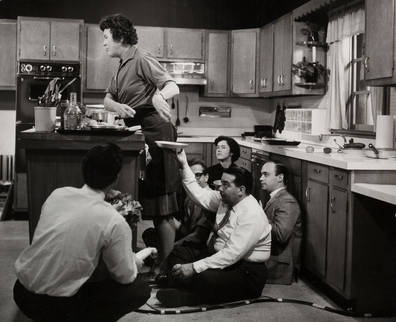 Child is joined by crew members on the set of "The French Chef" in 1963.
