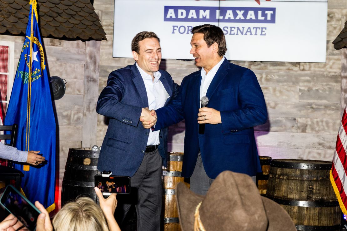 Desantis shakes hands with Laxalt on stage. 