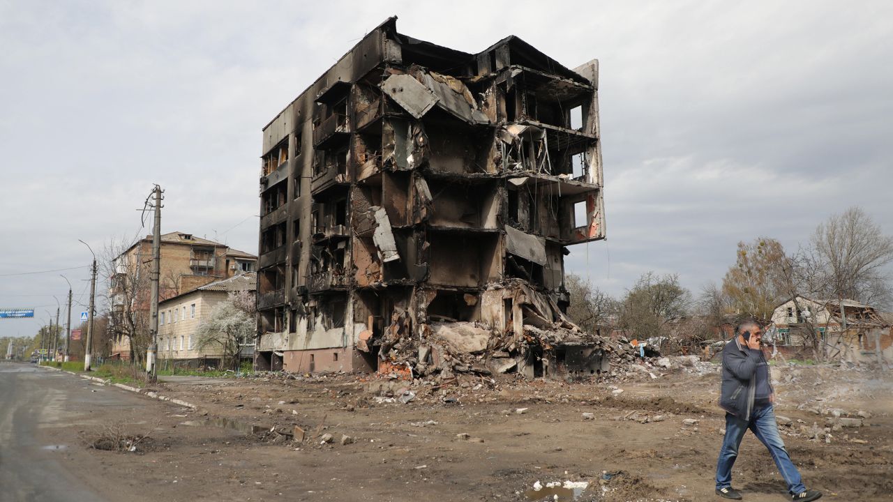 A man talking on the phone walks past the ruins of an apartment block destroyed as a result of Russian shelling in Borodianka, an urban-type settlement liberated from Russian invaders, Kyiv Region, northern Ukraine, on April 25, 2022.