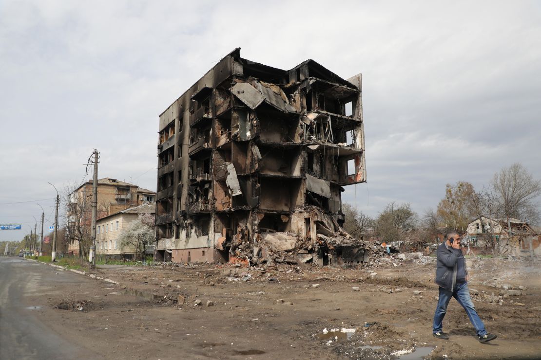 A man talking on the phone walks past the ruins of an apartment block destroyed as a result of Russian shelling in Borodianka, an urban-type settlement liberated from Russian invaders, Kyiv Region, northern Ukraine, on April 25, 2022. 