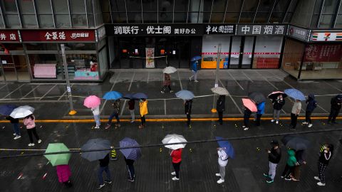 I residenti bloccati si allineano sotto la pioggia per i test Covid a Pechino il 27 aprile.