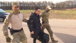 Former U.S. Marine Trevor Reed, who was detained in 2019 and accused of assaulting police officers, is escorted to a plane by Russian service members as part of a prisoner swap between the U.S. and Russia, in Moscow, Russia, in this still image taken from video released April 27, 2022. RU24/Handout via REUTERS TV  ATTENTION EDITORS - THIS IMAGE WAS PROVIDED BY A THIRD PARTY. NO RESALES. NO ARCHIVES. MANDATORY CREDIT. RUSSIA OUT. NO COMMERCIAL OR EDITORIAL SALES IN RUSSIA.