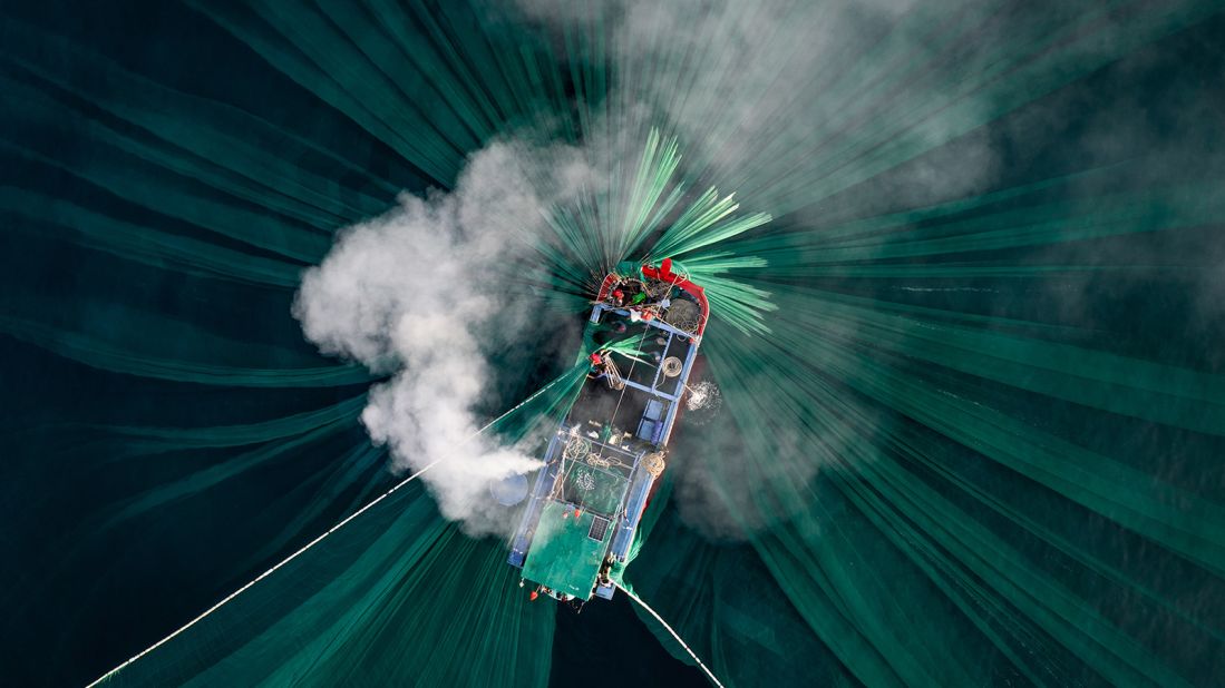 <strong>Southeast Asia winner | Thien Nguyen Ngoc of Vietnam | "Anchovy Catching":</strong> The soft light of a new day illuminates the exhaust from a fishing boat engine. Many local fishing families along the coastline of Phú Yên province will follow the near-shore currents to catch anchovy during peak season.