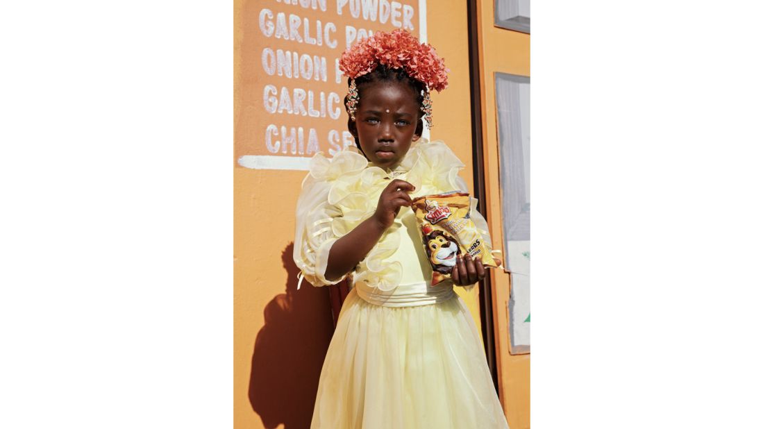 <strong>African Territory winner | Marguerite Oelofse of South Africa | "Flower Girl With a Packet of Simba Chippies":</strong> In the 1950s, South Africans were introduced to Simba Chippies. Simba, the Lion, is one of the country's most famous icons, and this potato snack is a national favorite.