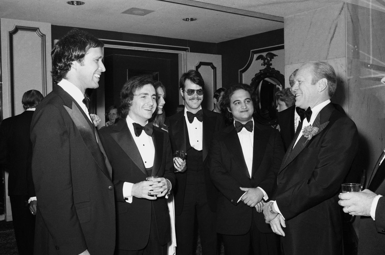 President Gerald Ford, right, speaks with comedian Chevy Chase, left, in 1976. Chase famously portrayed Ford as clumsy on "Saturday Night Live." Between the two, from left, are "Saturday Night Live" creator Lorne Michaels and cast members Dan Aykroyd and  John Belushi.