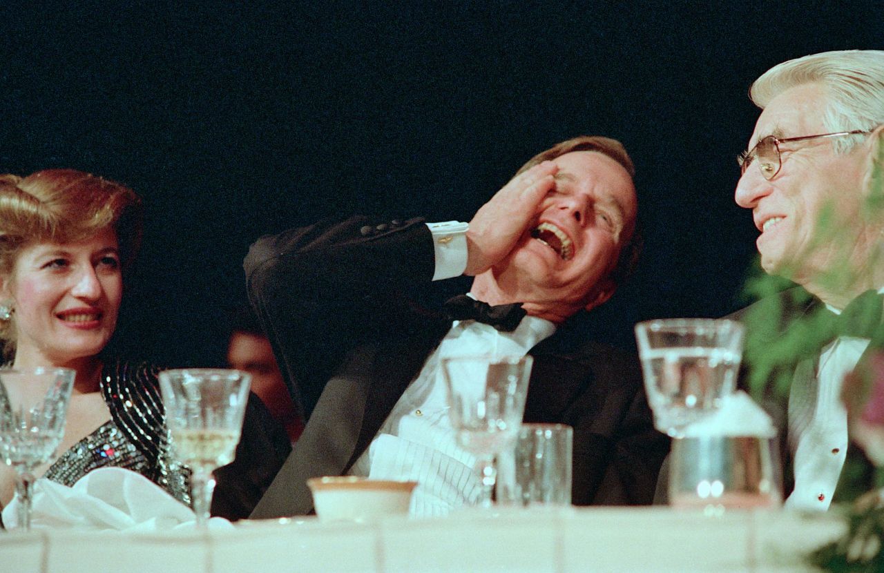 President George H.W. Bush laughs while watching Jim Morris do an impression of him at the 1989 dinner.