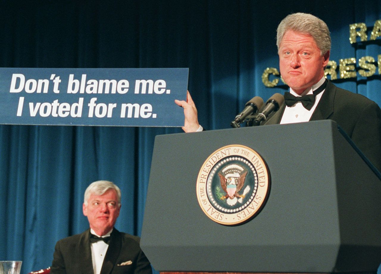 President Bill Clinton holds a placard proclaiming, "Don't blame me. I voted for me," at the dinner in 1996. Clinton was auditioning some potential slogans for bumper stickers.