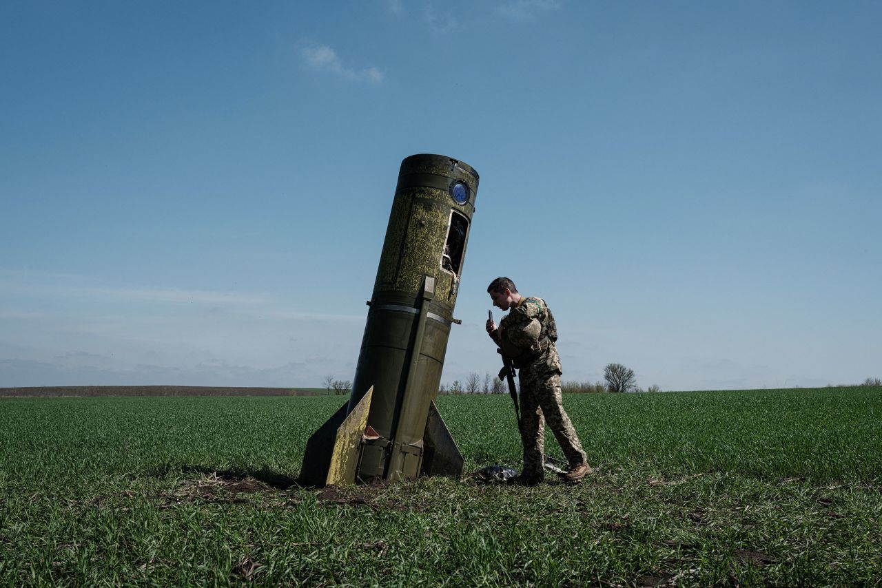 A Ukrainian serviceman looks at a Russian ballistic missile's booster stage that fell in a field in Bohodarove, Ukraine, on Monday, April 25.