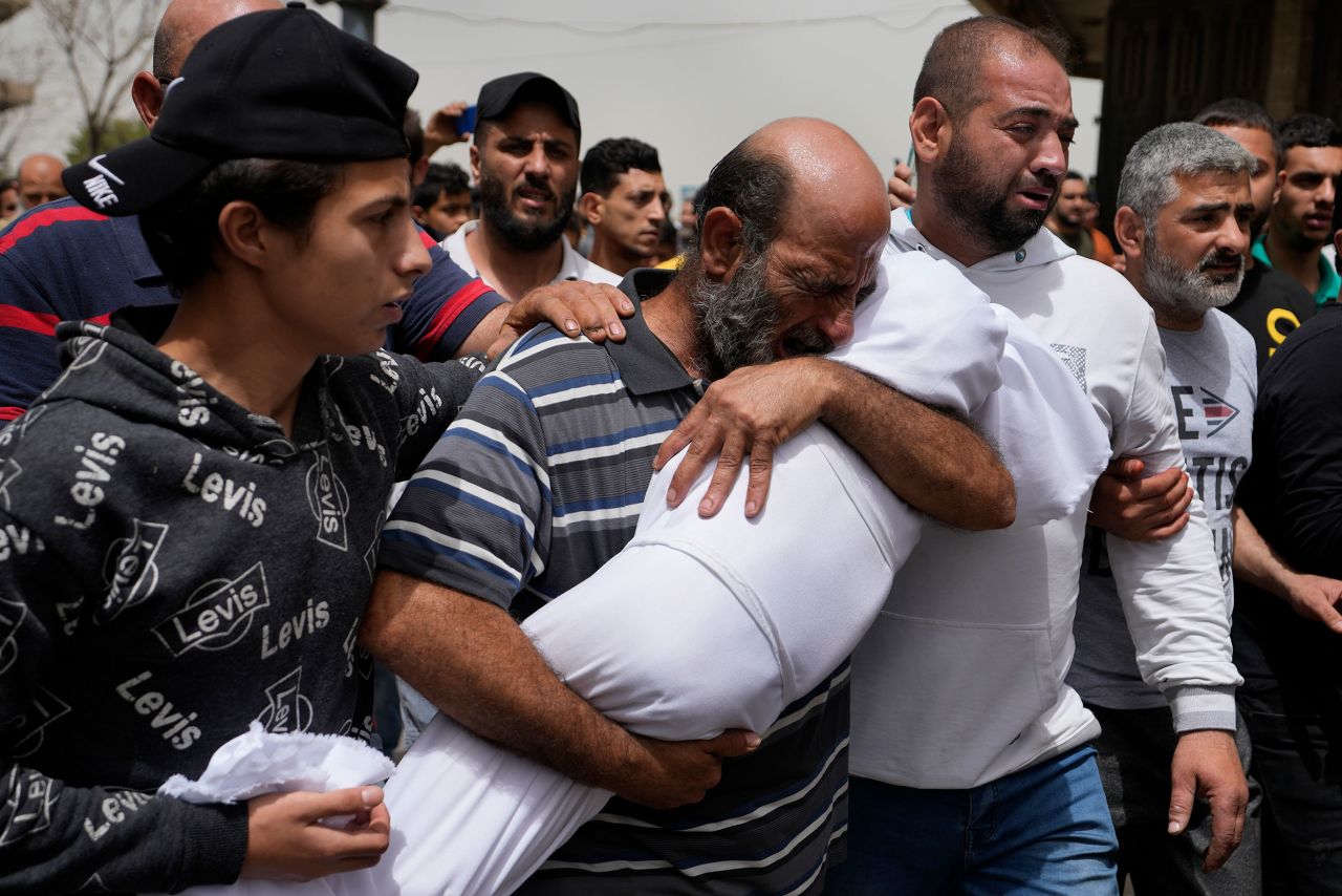 A man cries as he carries the body of a young girl during a funeral procession in Tripoli, Lebanon, on Monday, April 25. She was among seven people killed when a small boat packed with migrants sunk over the weekend.