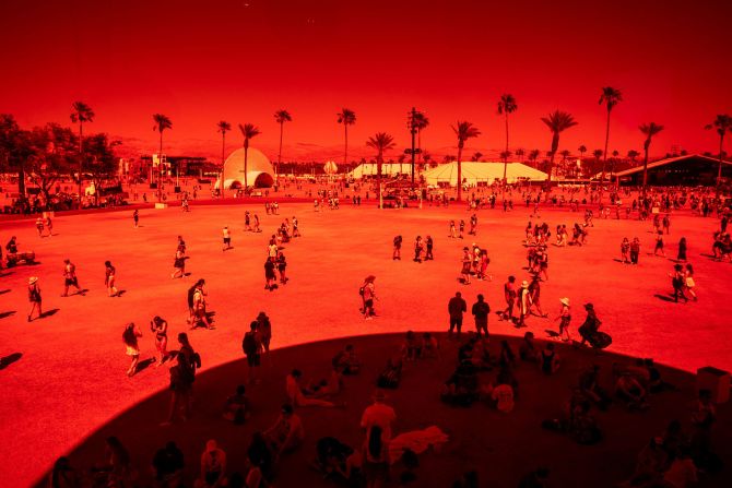 People walk outside "Spectra," a seven-floor art installation by Newsubstance, during the Coachella festival in Indio, California, on Saturday, April 23.