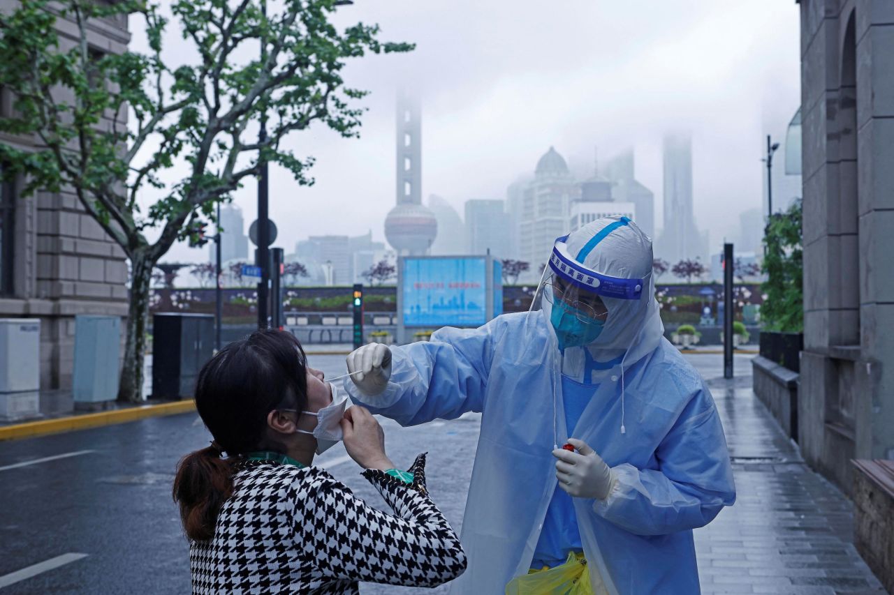 A medical worker in protective gear collects a swab sample from a Shanghai resident on April 26, 2022.