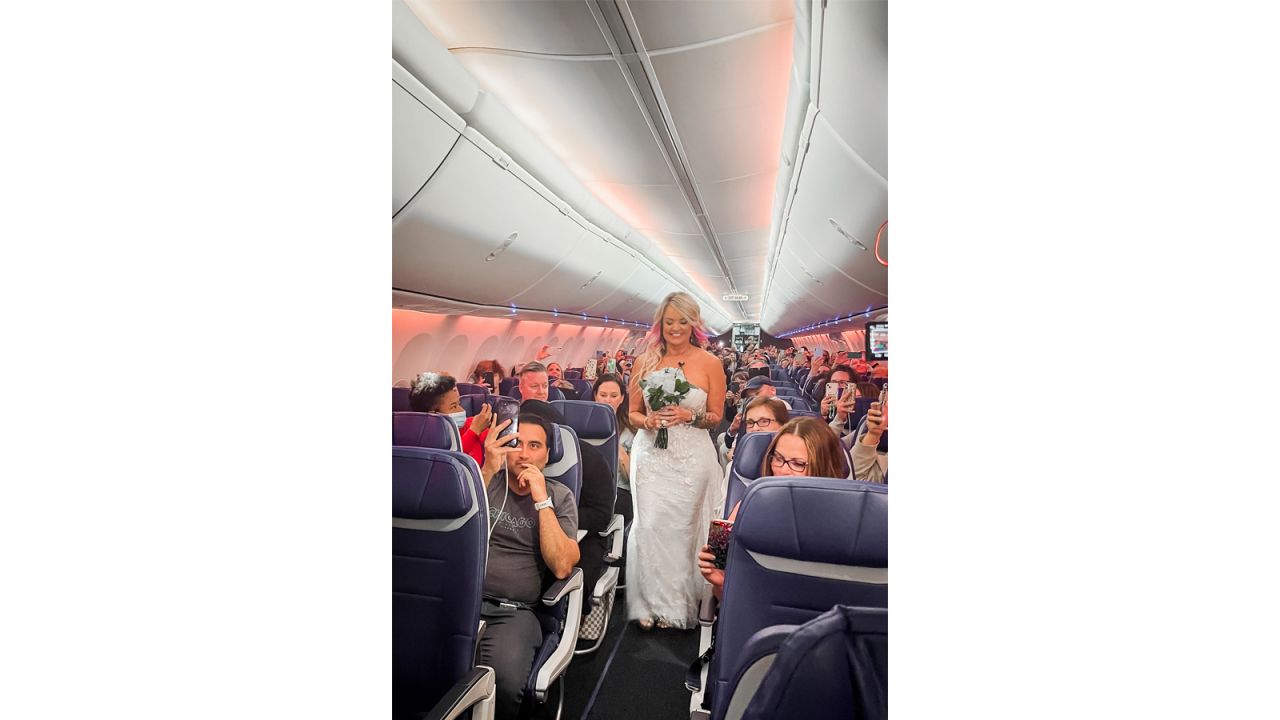 Pam made her way down the plane's aisle in her wedding gown as other passengers watched.
