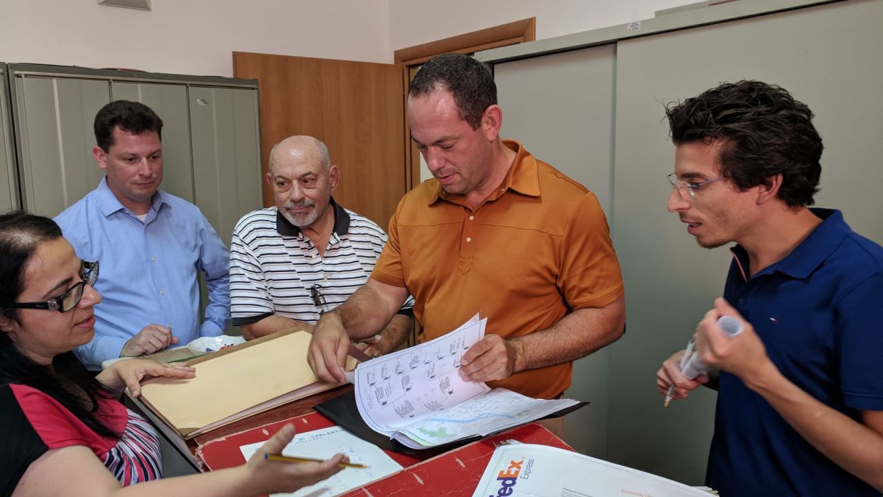 Curione, right, assists a family in Carlentini, Sicily, where some of their ancestors lived.