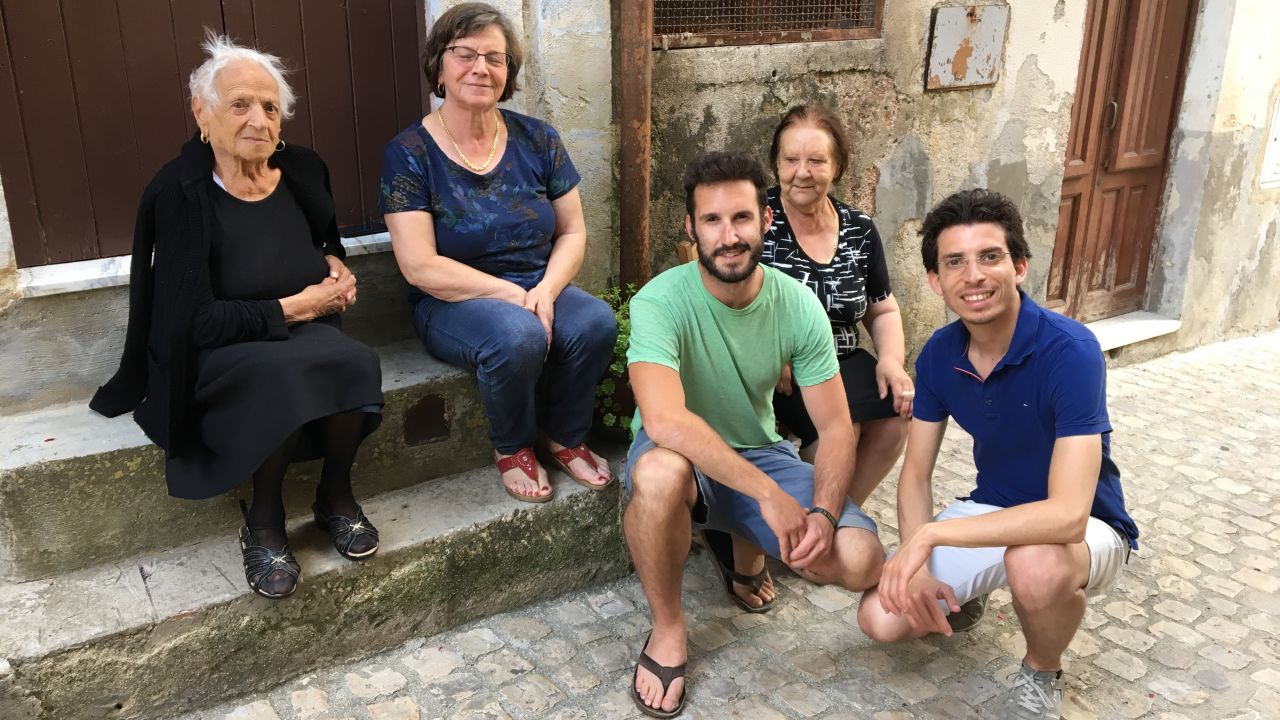 Francesco Curione, right, and a client meet with locals in the client's ancestral town.