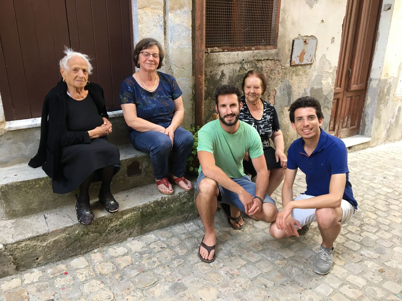 Francesco Curione, right, and a client meet with locals in the client's ancestral town.