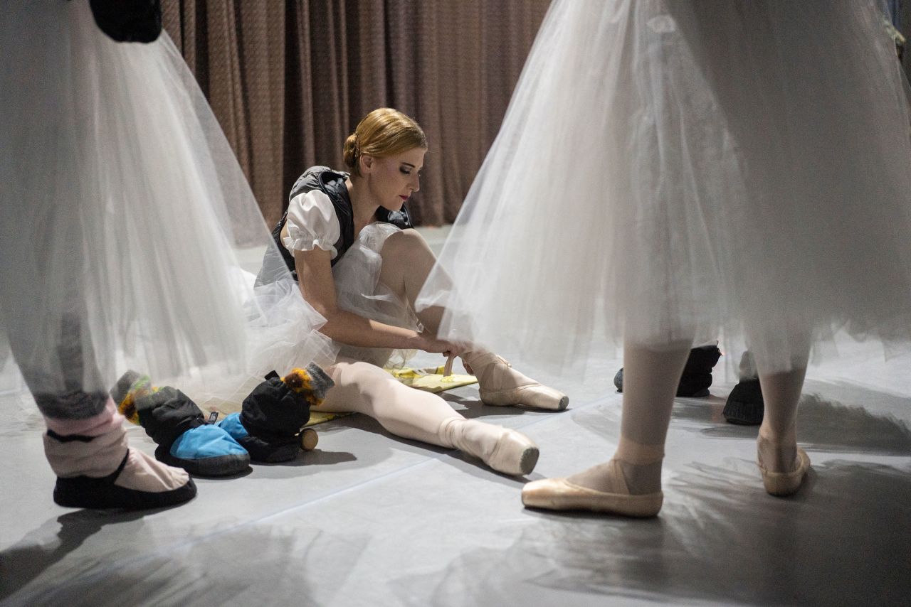 The show's ensemble cast make last preparations before the curtain opens.