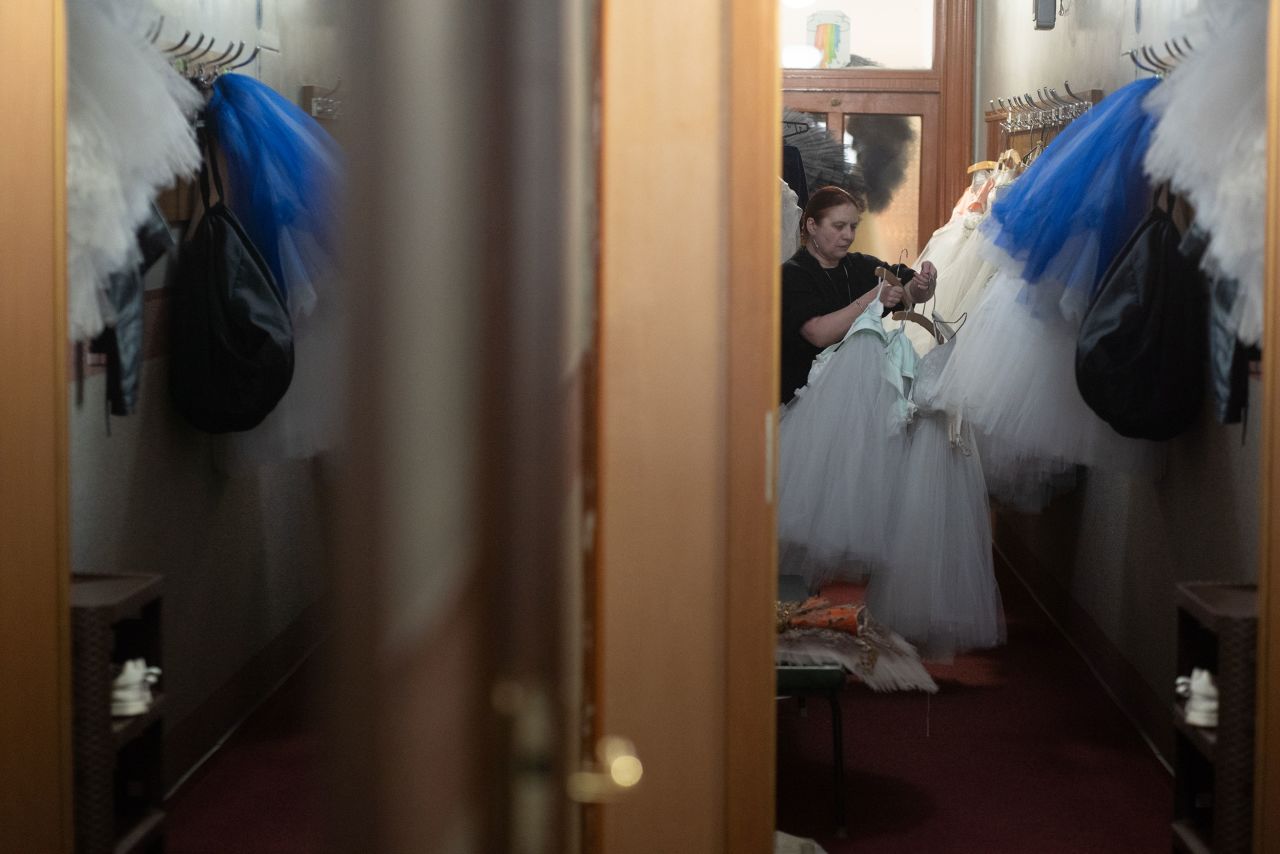 An employee prepares costumes for the evening production. 