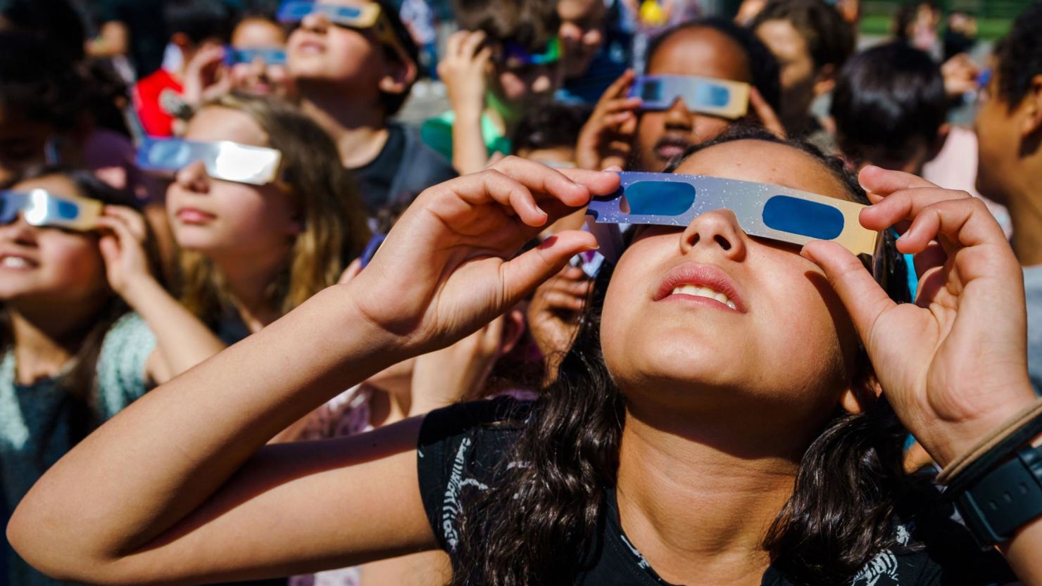 Students, wearing protective glasses, look at the partial solar eclipse in Schiedam in the Netherlands on June 10, 2021.