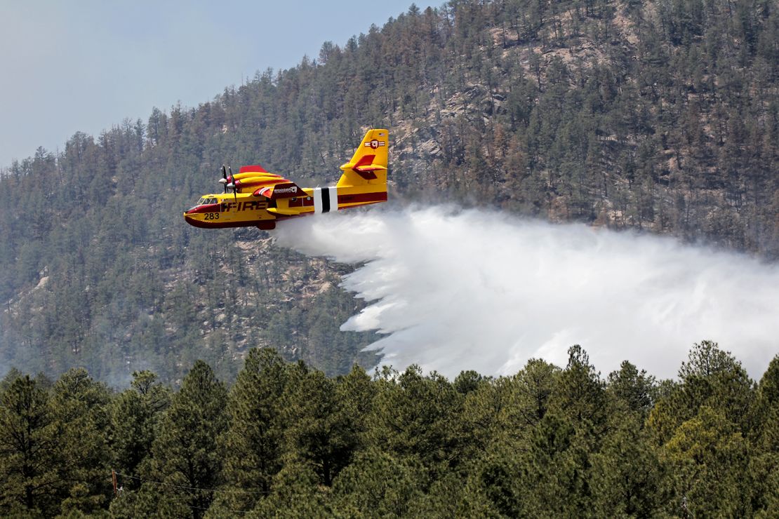 In this photo released by the U.S. Forest Service, an aircraft known as a "super scooper" battles the Hermits Peak and Calf Canyon Fires in the Santa Fe National Forest in New Mexico on Thursday, April 28, 2022. 
