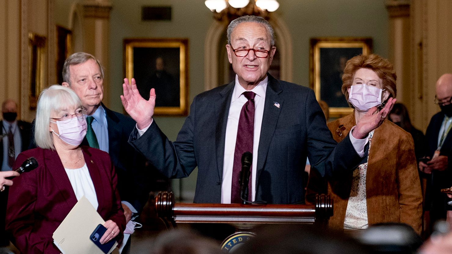 Senate Majority Leader Chuck Schumer speaks to reporters at the US Capitol on October 19, 2021, flanked by, from left, Sens. Patty Murray, Dick Durbin and Debbie Stabenow.