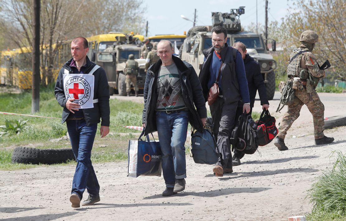 Civilians who left the area near Azovstal steel plant in Mariupol walk accompanied by a member of the International Committee of the Red Cross (ICRC) at a temporary accommodation centre during Ukraine-Russia conflict in the village of Bezimenne in the Donetsk Region, Ukraine May 1, 2022. REUTERS/Alexander Ermochenko