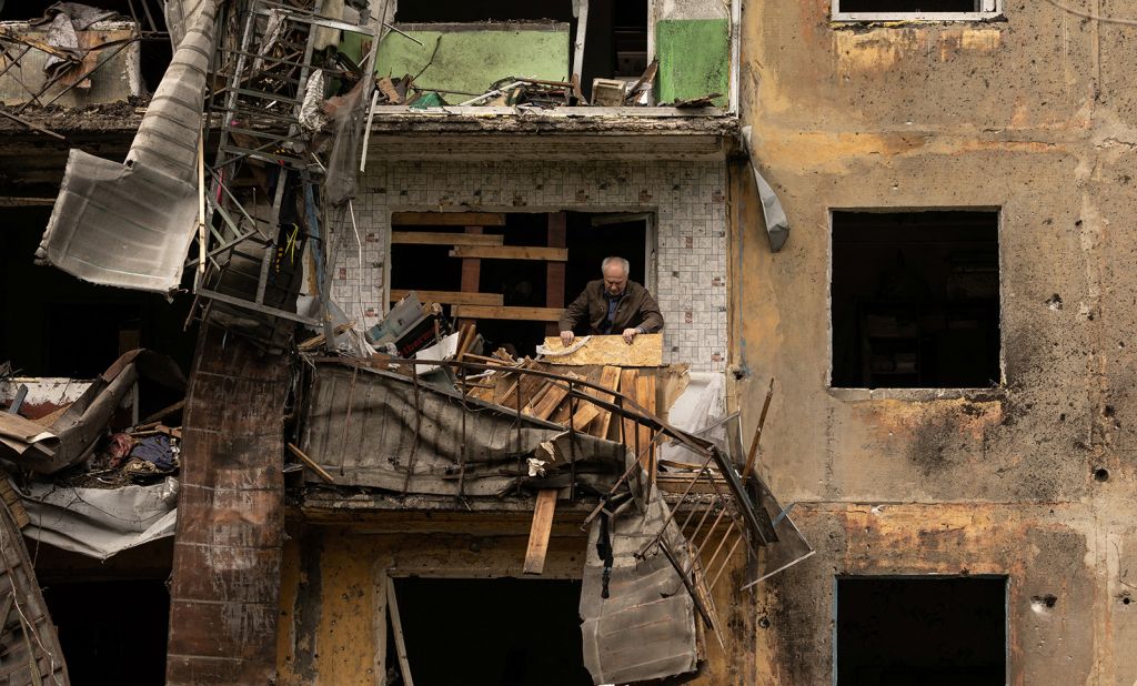 A man stands on the balcony of his apartment after a missile strike damaged a residential building in Ukraine's Donetsk region on April 30.