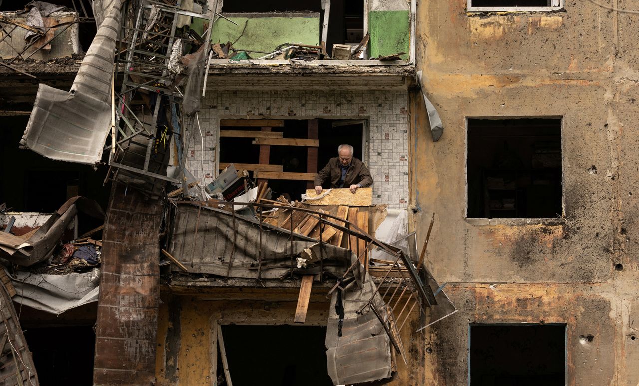 A man stands on the balcony of his apartment after a missile strike damaged a residential building in Ukraine's Donetsk region on April 30.  Zelensky says Russia waging war so Putin can stay in power &#8216;until the end of his life&#8217; 220501150721 01 damaged balcony donetsk 0430