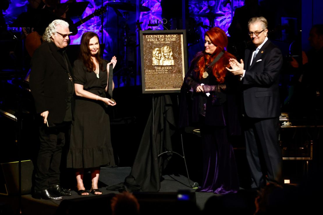 Wynonna Judd, second from the right, stands next to The Judds' induction plaque as sister Ashley Judd, left, Ricky Skaggs, and MC Kyle Young, CEO of the Country Music Hall of Fame & Museum look on during the Medallion Ceremony at the Country Music Hall of Fame on Sunday.