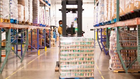 A Second Harvest Heartland staffer moves a pallet of canned goods in the food bank's warehouse in Brooklyn Park, Minnesota.
