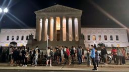 A crowd of people gather outside the Supreme Court, Monday night, May 2, 2022 in Washington. 