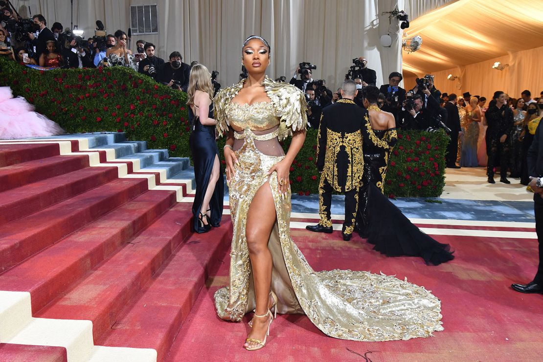 Megan Thee Stallion opted for a golden gown with sculpted feather-like shoulders by Moschino and attended the event alongside the brand's creative director Jeremy Scott. 